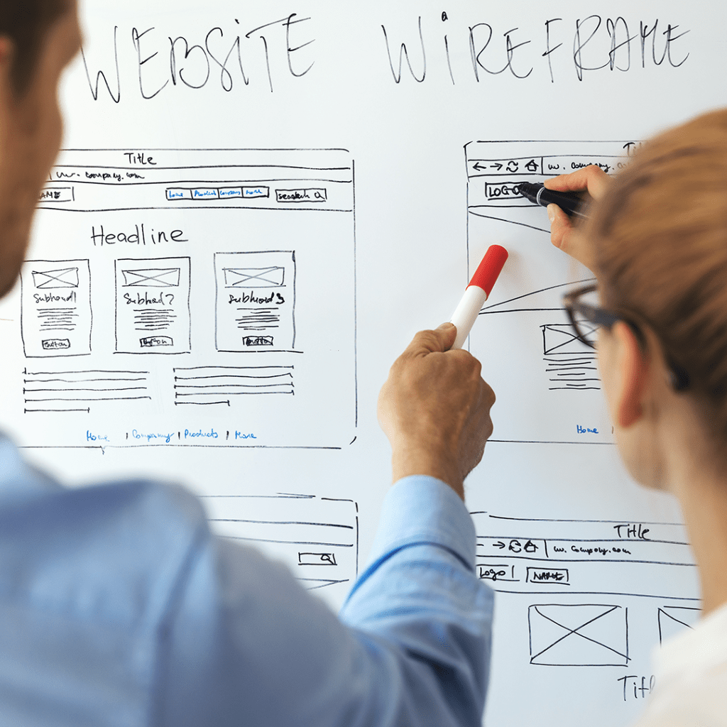 Website design content planning. Man and woman pointing to website content ux plan on white board